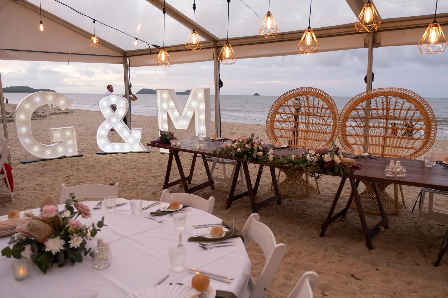 Melaleuca Resort - Palm cove weddings - Bridal table setup on the beach with beautiful flowers and cane chairs